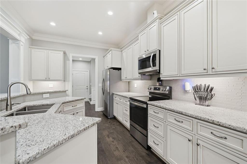 1006 Owens Store Road Canton, GA 30115 - Photo 11 of 48 a kitchen with stainless steel appliances granite countertop a sink stove refrigerator and cabinets