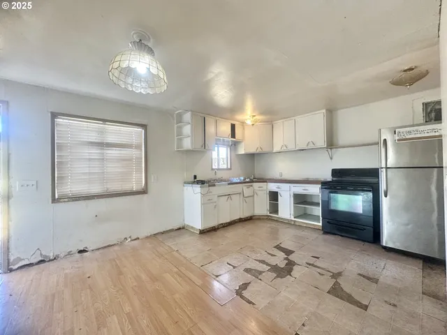 a kitchen with stainless steel appliances granite countertop a refrigerator a sink dishwasher a stove with wooden cabinets and floor