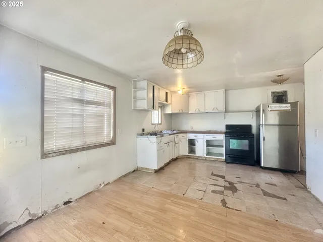 a kitchen with stainless steel appliances a large counter top a sink cabinets and a window