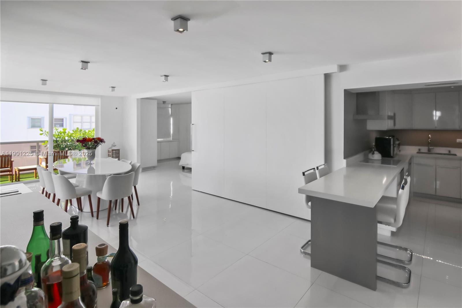 6039 Collins Avenue, Unit 1402 Miami Beach, FL 33140 - Photo 15 of 45 a living room with furniture a chandelier and a dining table
