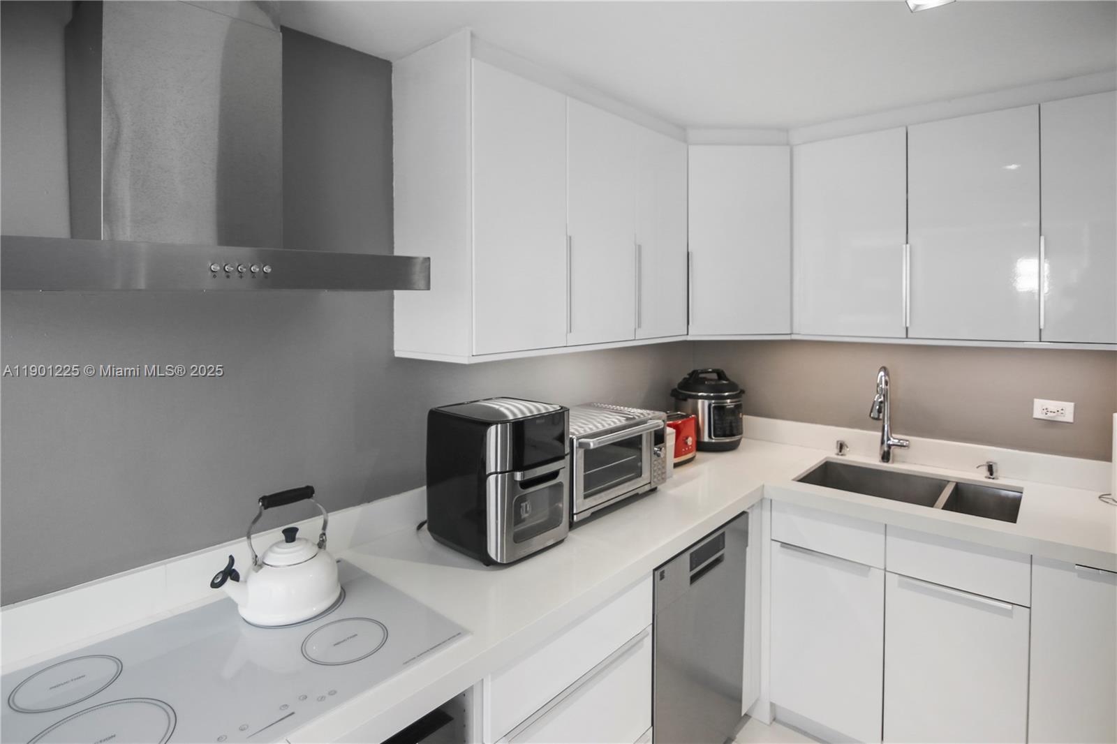 6039 Collins Avenue, Unit 1402 Miami Beach, FL 33140 - Photo 18 of 45 a kitchen with stainless steel appliances granite countertop a sink a stove white cabinets with white countertops and cabinets