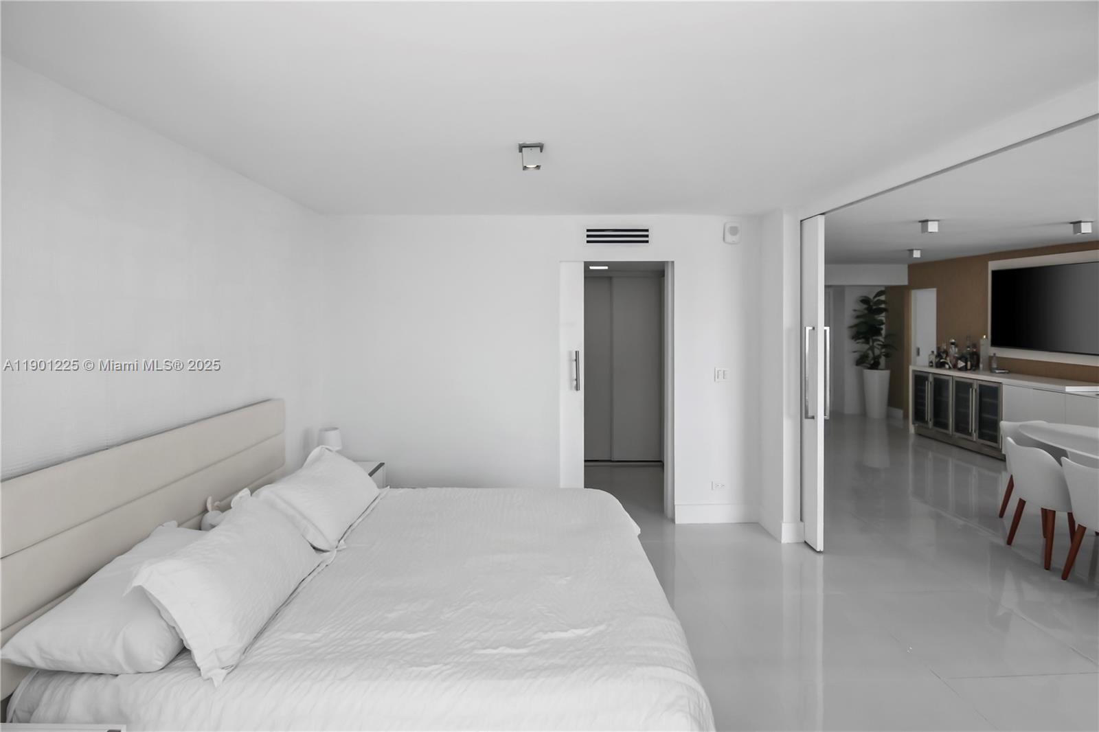 6039 Collins Avenue, Unit 1402 Miami Beach, FL 33140 - Photo 23 of 45 a bed room with a bed and a television