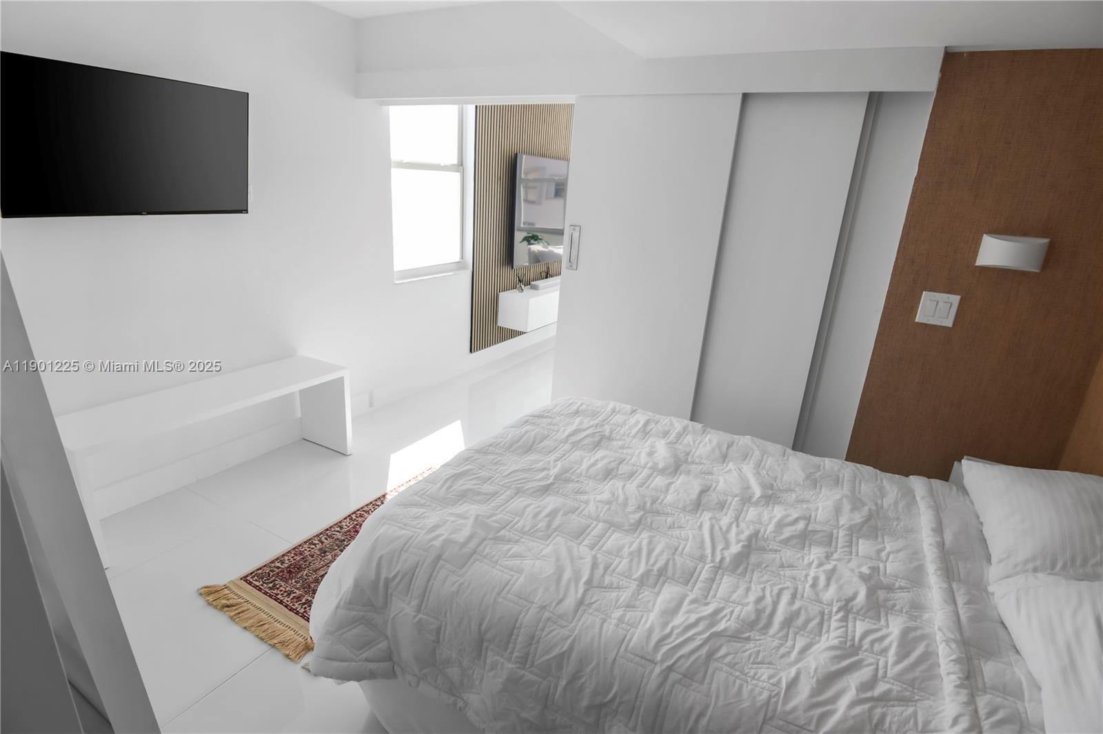 6039 Collins Avenue, Unit 1402 Miami Beach, FL 33140 - Photo 27 of 45 a bedroom with a bed and a flat screen tv