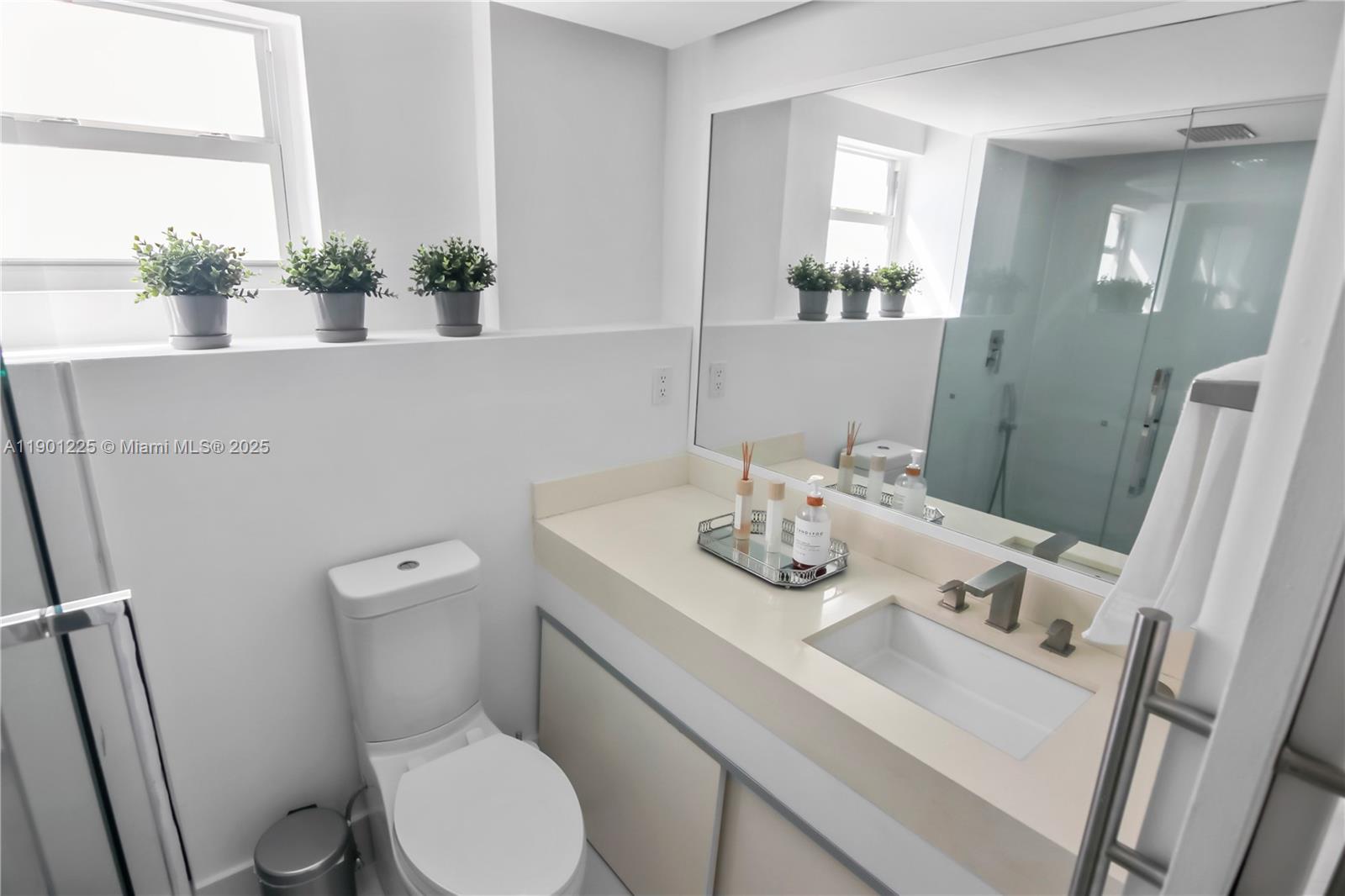 6039 Collins Avenue, Unit 1402 Miami Beach, FL 33140 - Photo 28 of 45 a bathroom with a sink toilet and mirror