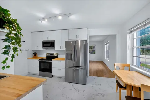 a kitchen with granite countertop a refrigerator and a stove top oven