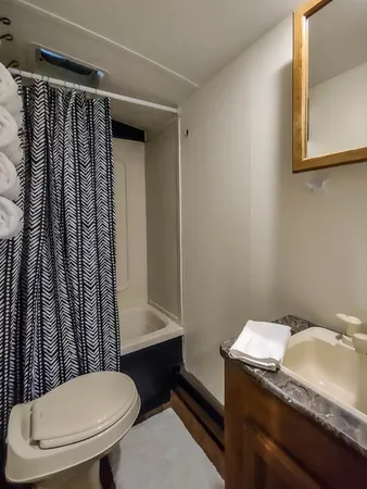 a bathroom with a granite countertop toilet sink and mirror