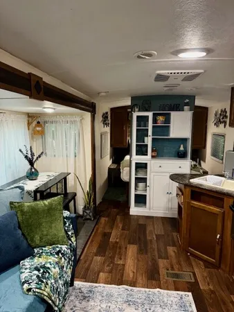 a kitchen with stainless steel appliances granite countertop a refrigerator a stove and a sink with wooden floor