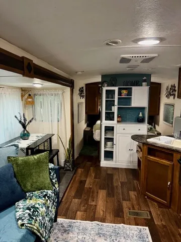 a kitchen with stainless steel appliances granite countertop a refrigerator a stove and a sink with wooden floor