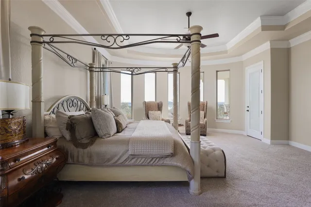 a spacious bedroom with a bed a chandelier and a large window
