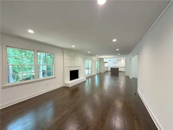 a view of empty room with wooden floor and windows