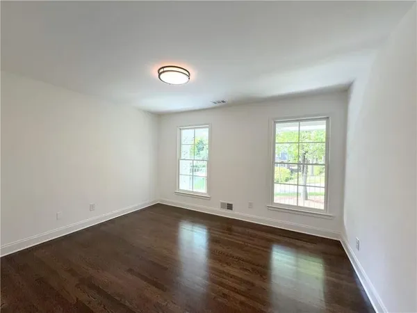 a view of a room with wooden floor and windows