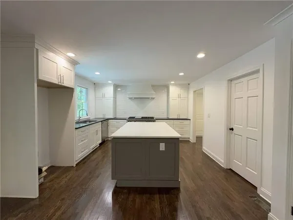 a kitchen with stainless steel appliances granite countertop white cabinets and a stove
