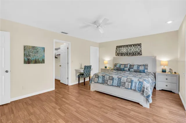 a bedroom with a large bed and a chandelier
