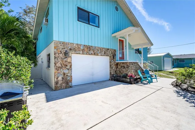 a view of a house with potted plants and a garage