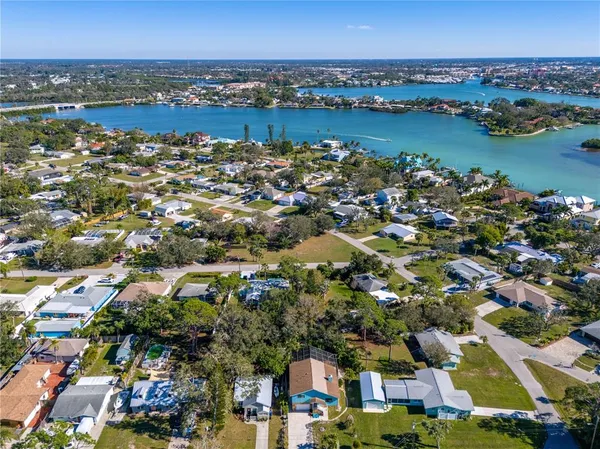 an aerial view of city and lake with trees all around