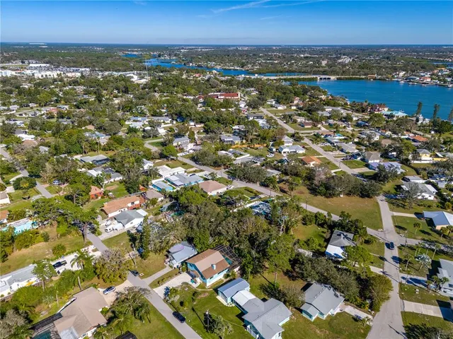 an aerial view of residential houses with outdoor space and lake view