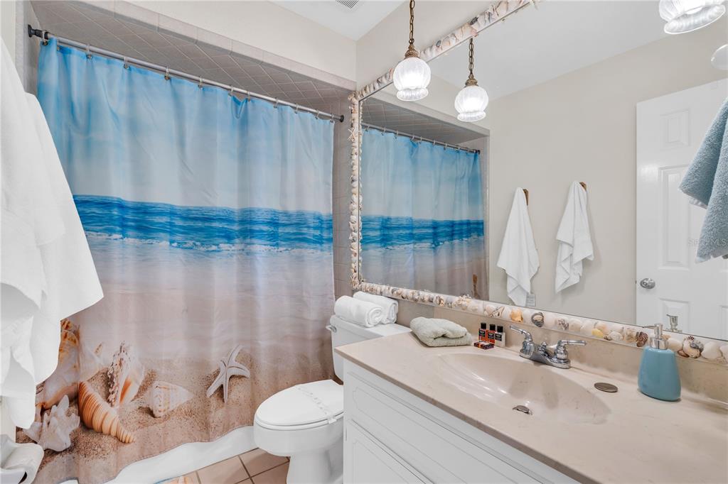 521 Pameto Road Nokomis, FL 34275 - Photo 9 of 41 a bathroom with a sink a toilet and shower curtain