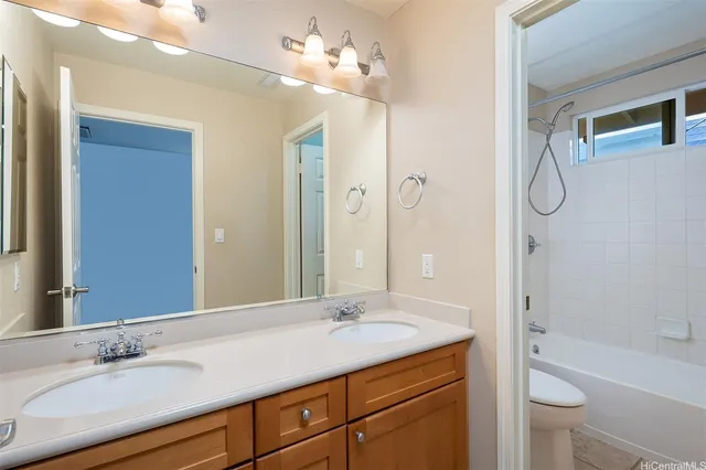 a bathroom with a granite countertop sink a toilet a mirror and shower