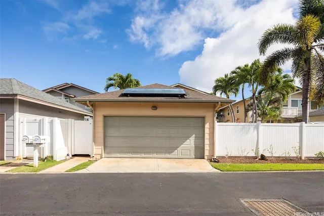 a view of yellow house with a yard and plants