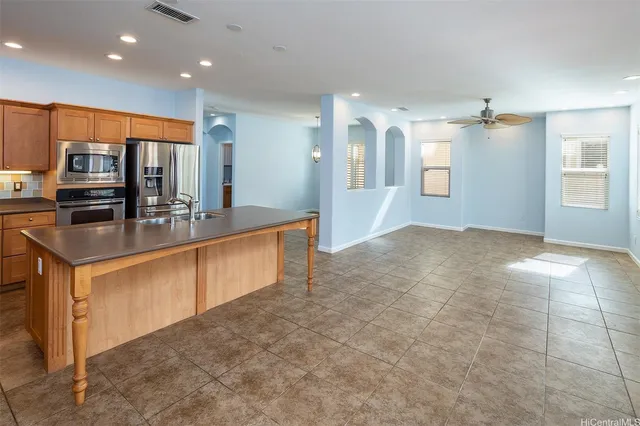 a kitchen with stainless steel appliances granite countertop a sink a stove and a refrigerator