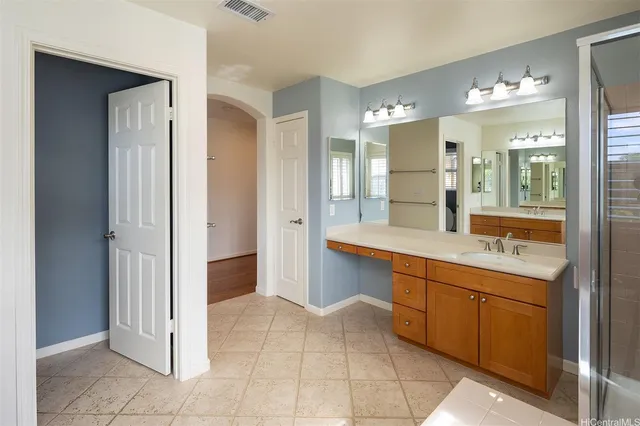 a spacious bathroom with a granite countertop sink a mirror and a shower