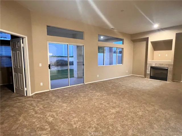 a view of an empty room with a window and a fireplace