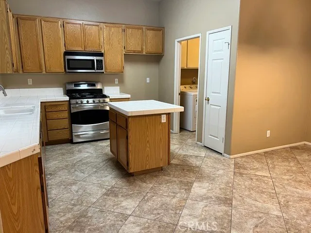 a kitchen with granite countertop a stove and a microwave