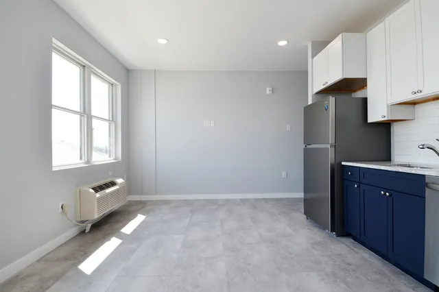 a view of kitchen with granite countertop cabinets and window