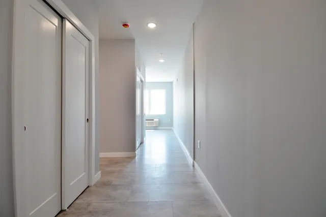 a view of a hallway with wooden floor