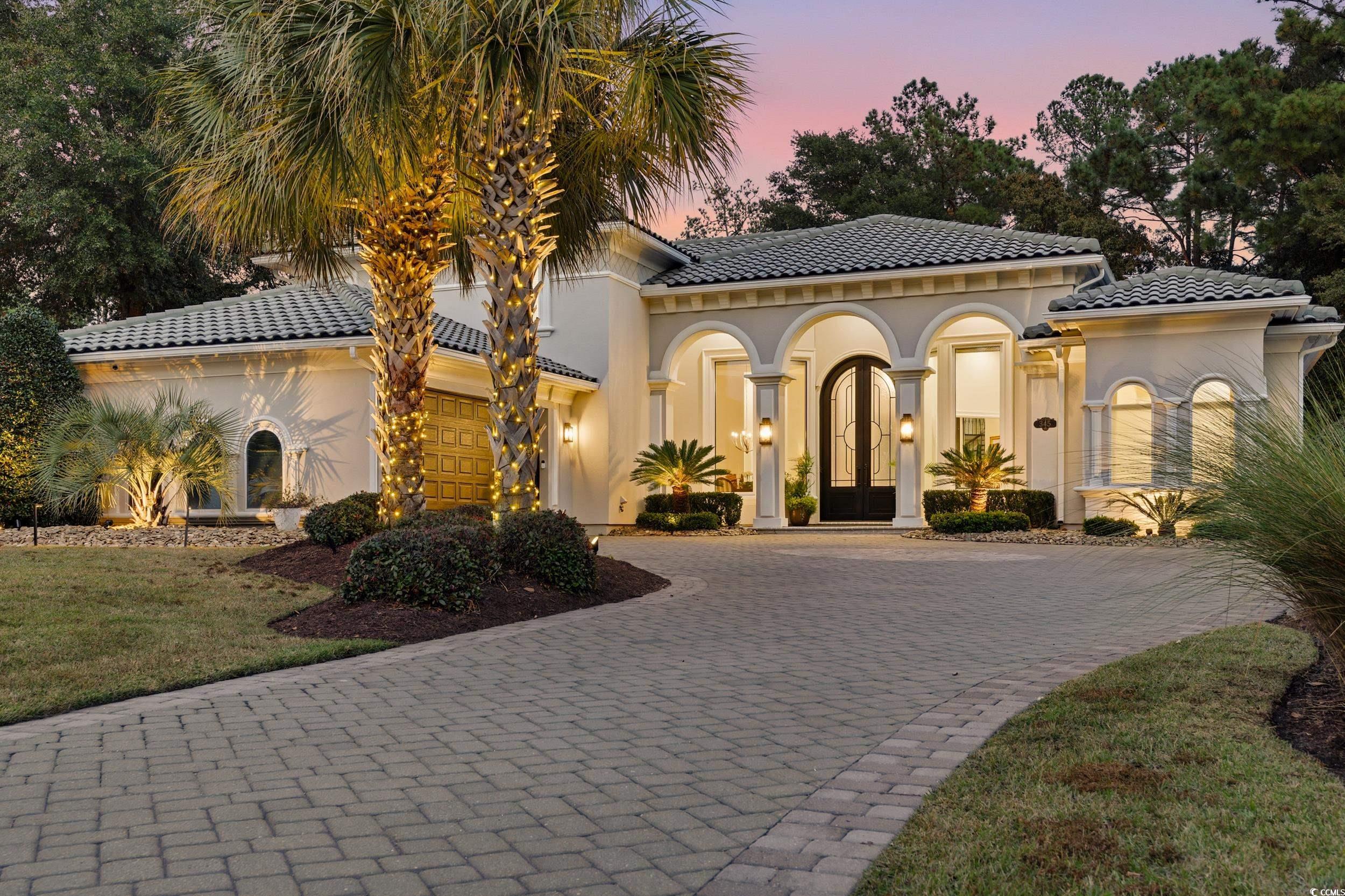 Mediterranean / spanish home featuring decorative paver driveway, stucco siding, a tile roof, a metal decorative
