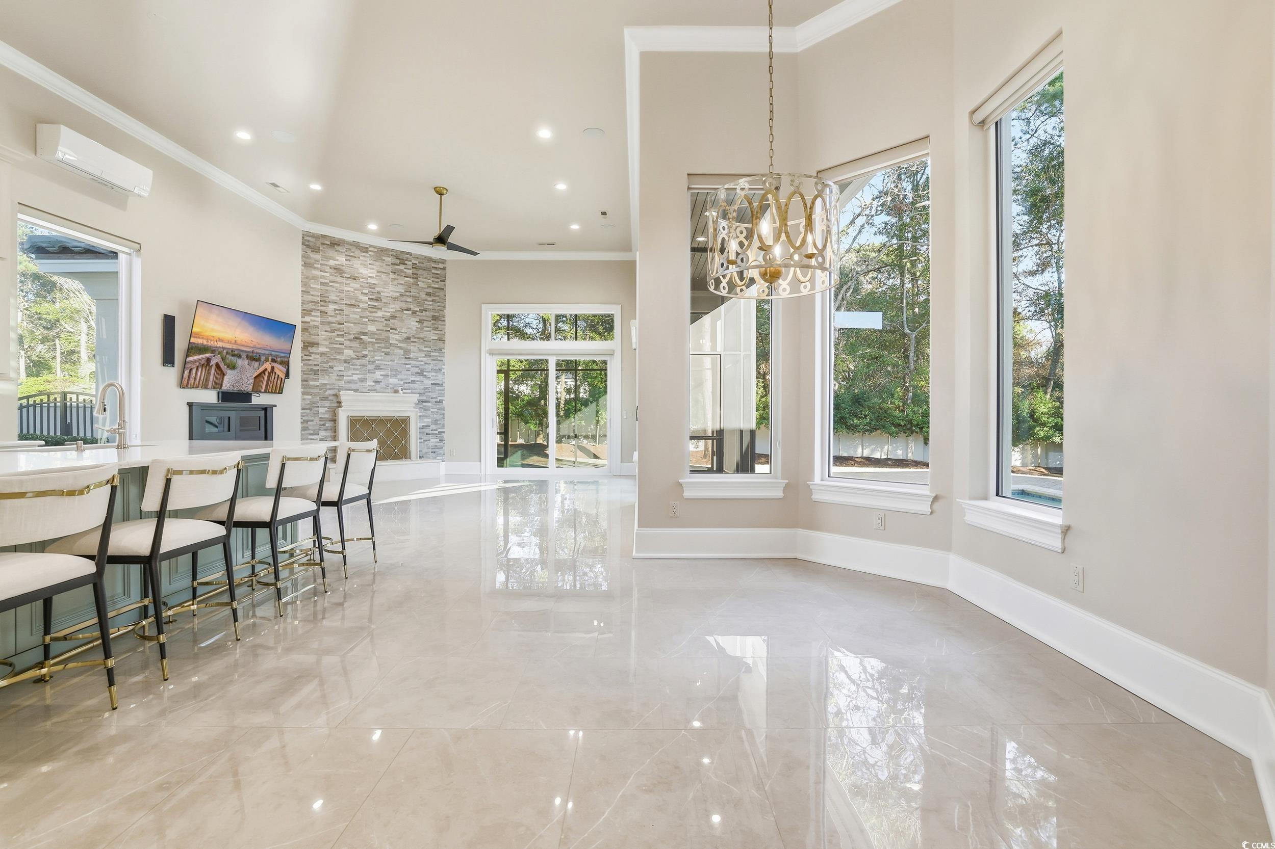 345 Posada Drive Myrtle Beach, SC 29572 - Photo 15 of 40 Breakfast room featuring a fireplace, crown molding, light marble finish floors, a chandelier, and recessed lighting