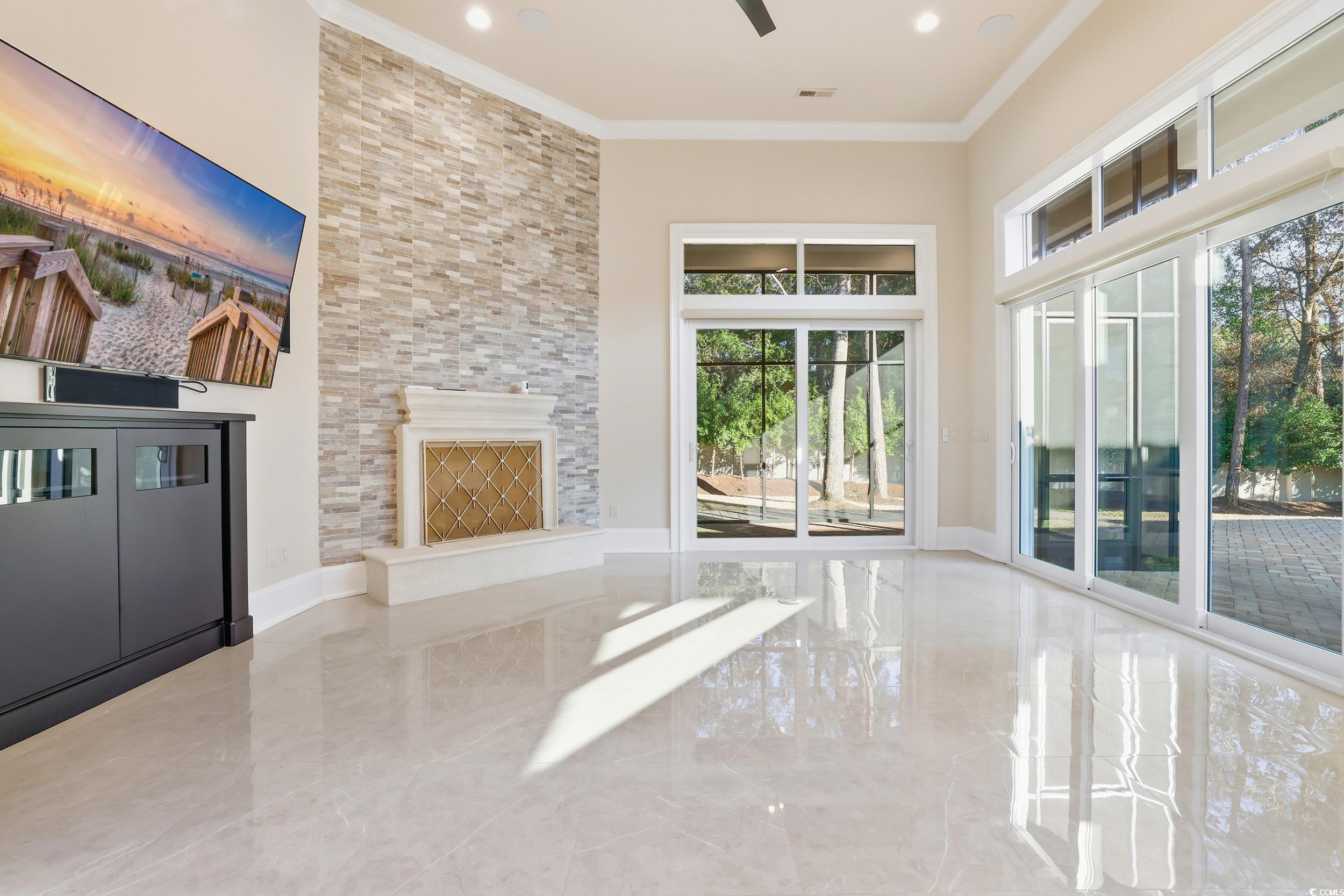 345 Posada Drive Myrtle Beach, SC 29572 - Photo 16 of 40 Family room featuring ornamental molding, a towering ceiling, Fireplace, marble tiled flooring, Sliders to screened in porch and ceiling fan