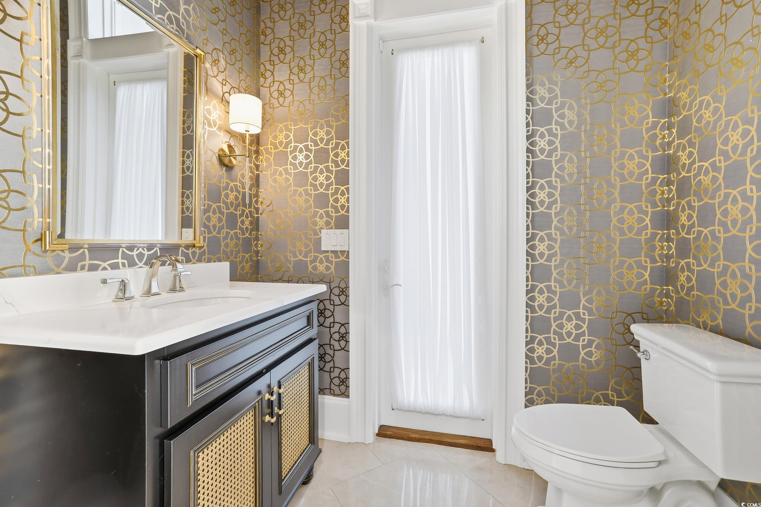 345 Posada Drive Myrtle Beach, SC 29572 - Photo 18 of 40 Powder Room featuring door to the patio/pool, vanity, wallpapered walls