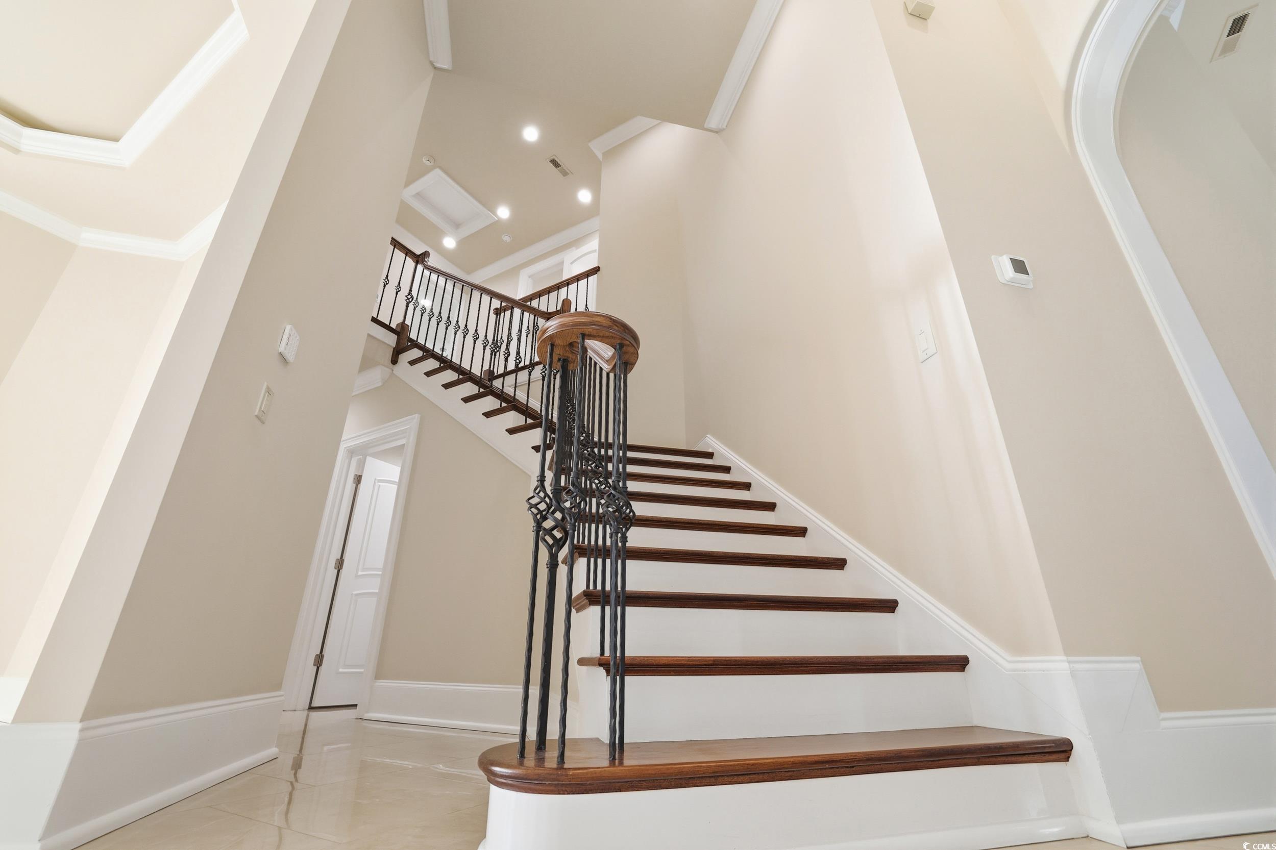 345 Posada Drive Myrtle Beach, SC 29572 - Photo 19 of 40 Staircase featuring Stained railing, crown molding and a high ceiling