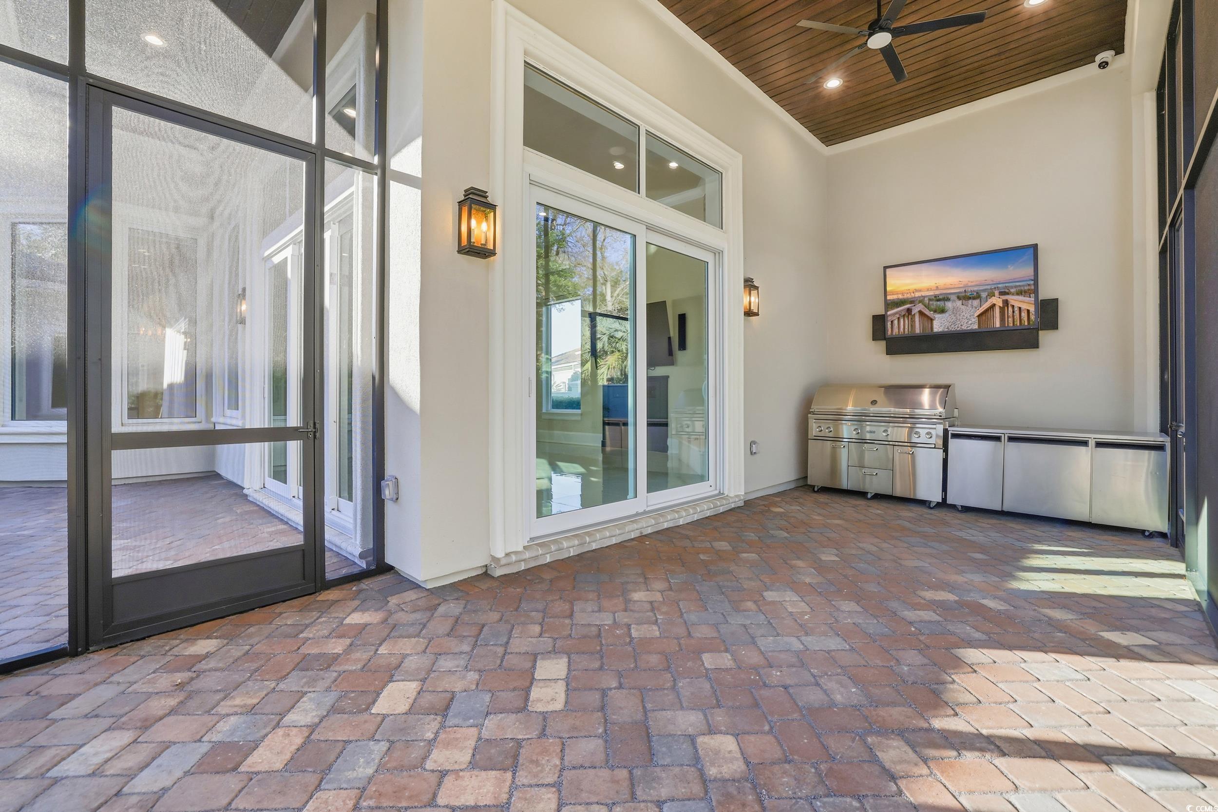 345 Posada Drive Myrtle Beach, SC 29572 - Photo 28 of 40 Screened Porch featuring outdoor kitchen and view of patio / terrace with area for grilling and ceiling fan
