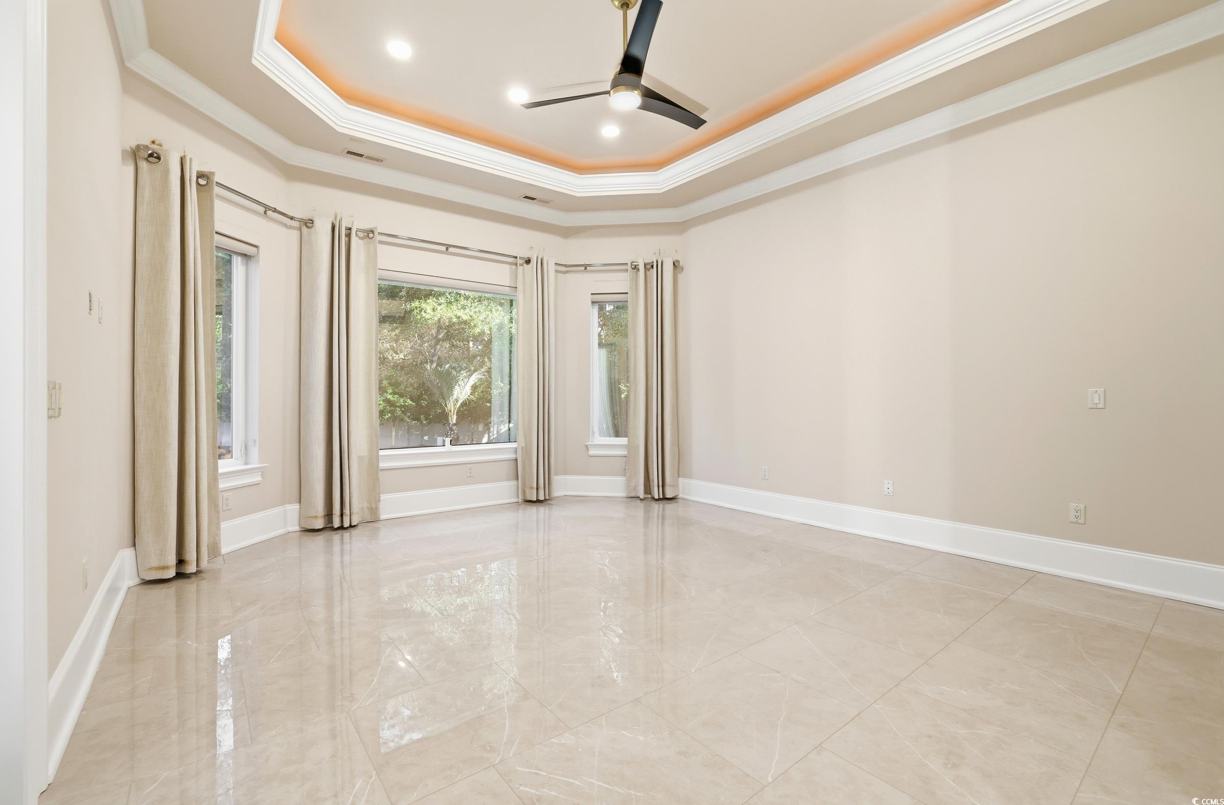 345 Posada Drive Myrtle Beach, SC 29572 - Photo 8 of 40 Primary bedroom featuring crown molding, a raised ceiling, light marble finish flooring, a ceiling fan, and recessed lighting