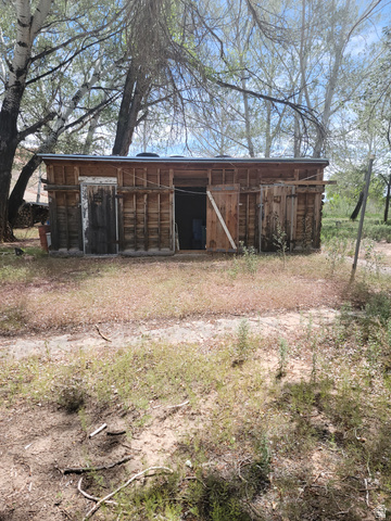 10429 4th Street East Randlett, UT 84063 - Photo 15 of 19 Rustic wood-sided outbuilding with 3 seperate units, surrounded by natural ground cover and mature trees
