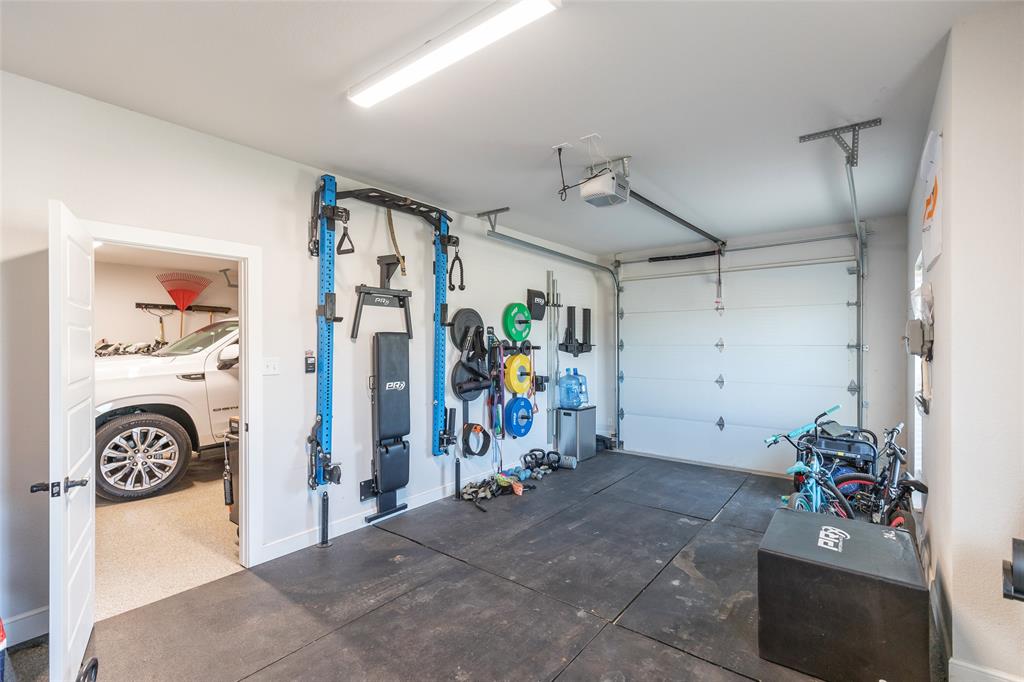 107 Kleingrass Road Abilene, TX 79606 - Photo 27 of 33 Attached two-car garage featuring a sectional garage door, overhead garage door opener, and durable rubber flooring