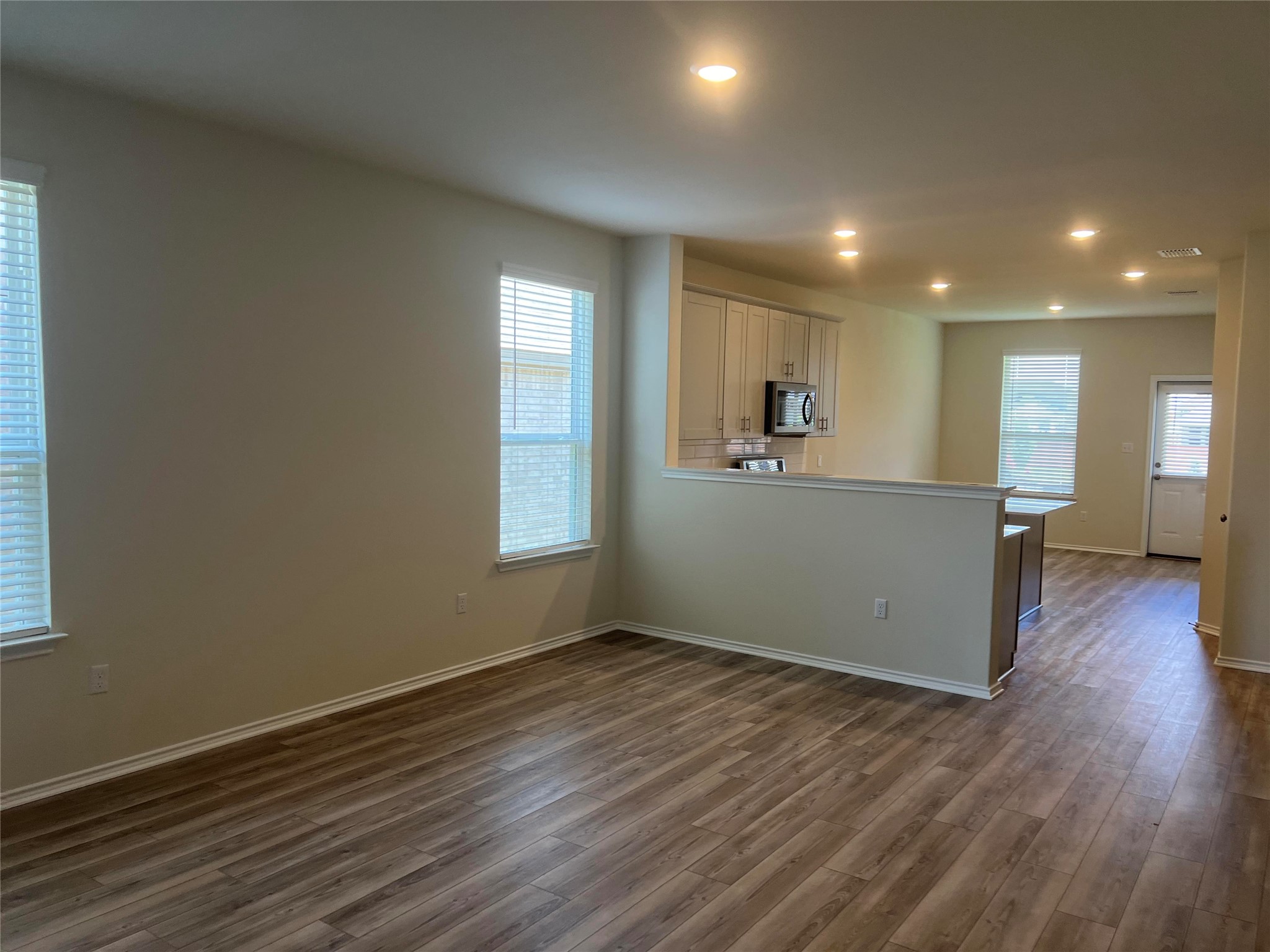 427 Tree Nut Loop Buda, TX 78610 - Photo 10 of 38 an empty room with wooden floor and windows
