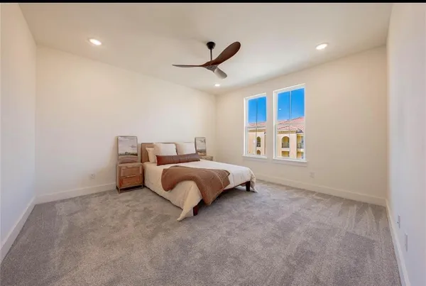 a spacious bedroom with a bed and a ceiling fan
