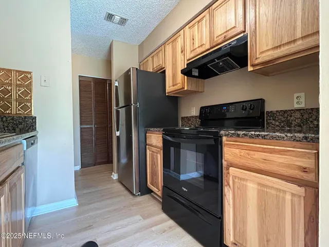 a kitchen with stainless steel appliances granite countertop a refrigerator stove and microwave