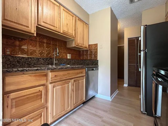 a kitchen with stainless steel appliances granite countertop a refrigerator and a sink