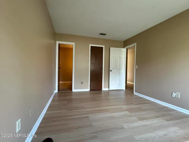 a view of an empty room with wooden floor