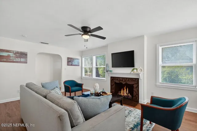 a living room with furniture a fireplace and a flat screen tv