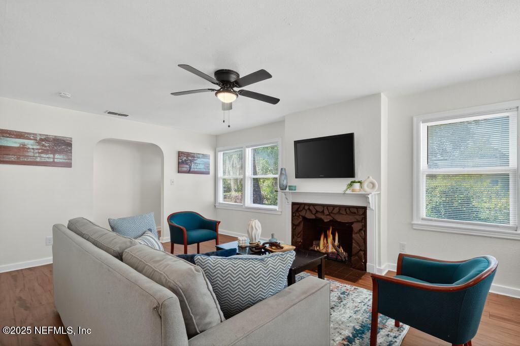a living room with furniture a fireplace and a flat screen tv