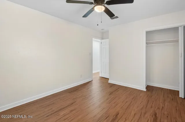 a view of an empty room with wooden floor
