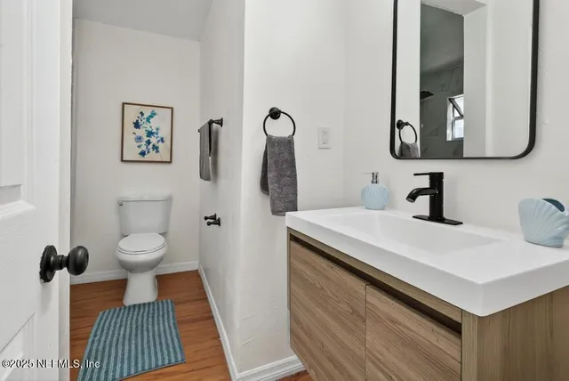 a bathroom with a sink toilet and a mirror