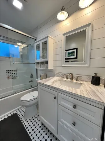 a bathroom with a granite countertop toilet sink and mirror