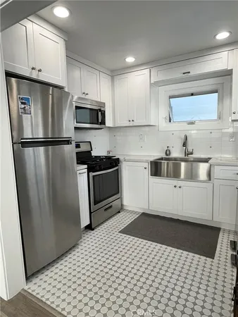 a kitchen with stainless steel appliances a refrigerator sink and cabinets