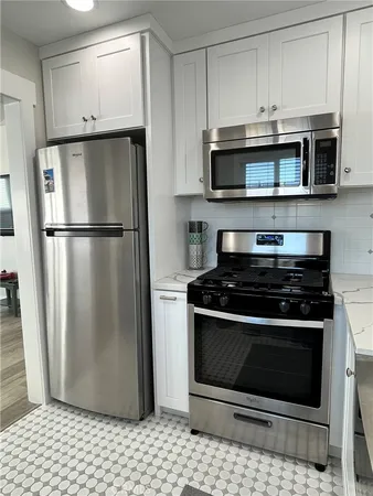 a kitchen with stainless steel appliances granite countertop a refrigerator stove and microwave